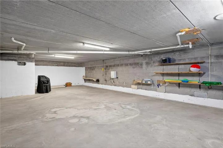 Spacious concrete garage with exposed overhead utilities