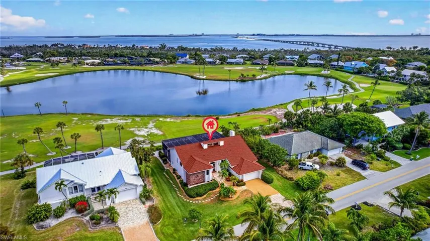 Aerial perspective showcasing a residential property with a terracotta-colored tile roof and an attached screened enclosure