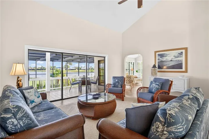 Vaulted ceilings enhance this living area featuring sliding glass doors opening to a screened lanai