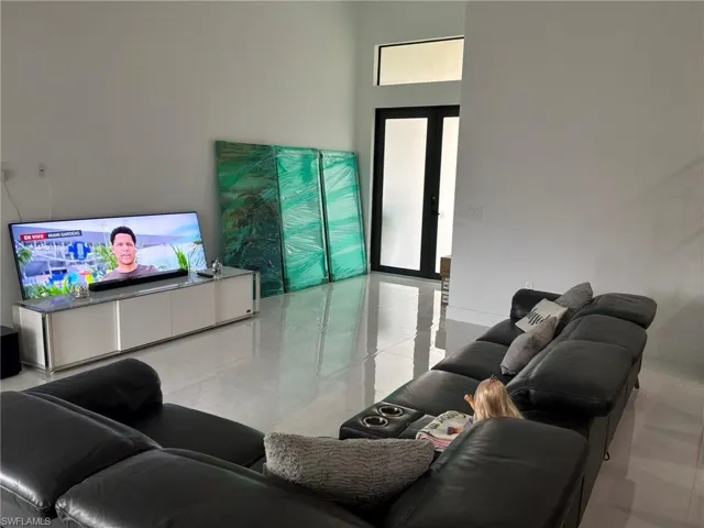 Living space with high ceilings and polished tile flooring