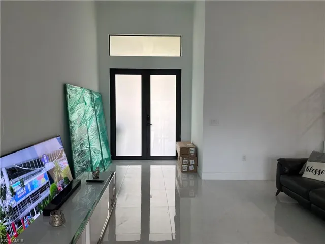 Double entry doors with frosted glass panels and a transom window above