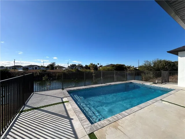 View of swimming pool featuring patio surround and a fenced backyard