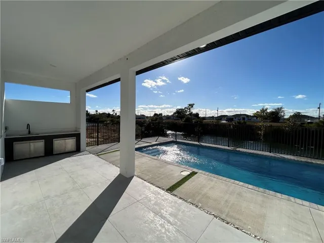 View of pool featuring a fenced backyard and area for grilling