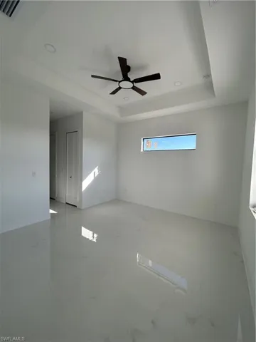 Spare room featuring ceiling fan, a tray ceiling, and recessed lighting