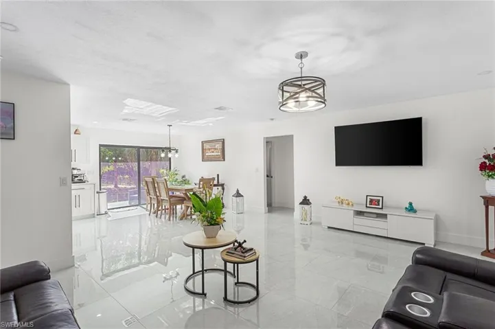 Living area with marble finish floor, baseboards, and a notable chandelier