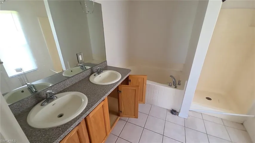 Double vanity with a speckled countertop and light wood cabinetry