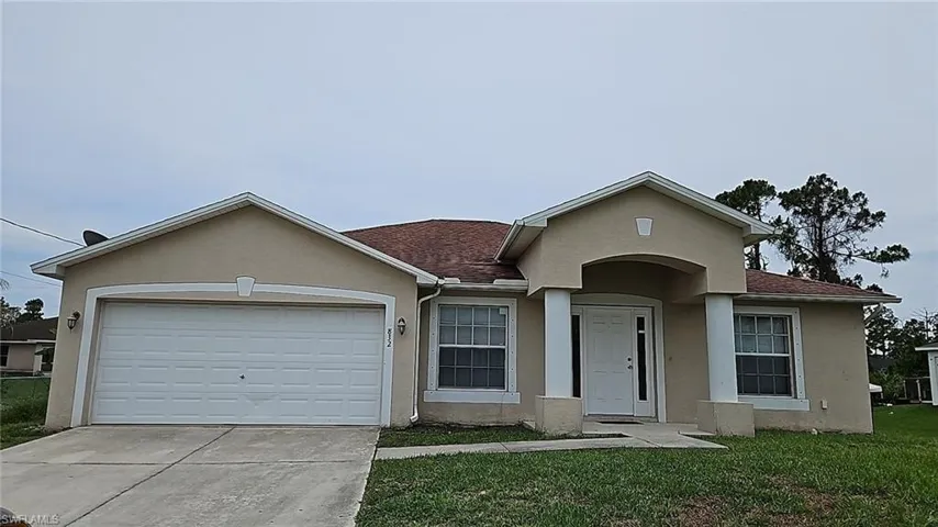 Single-story residence featuring a two-car garage, covered entry with dual columns, and multiple front-facing windows