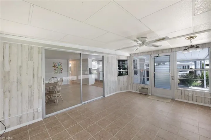 Unfurnished sunroom featuring a ceiling fan