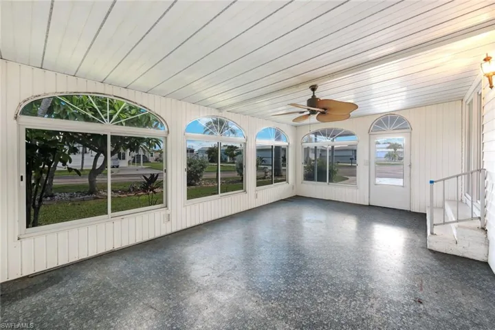 Unfurnished sunroom featuring a ceiling fan