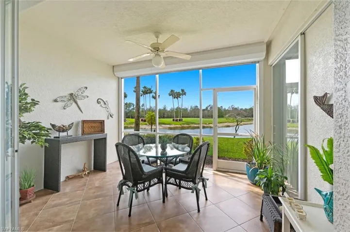 Sunroom / solarium with ceiling fan, outdoor dining area, and a water view
