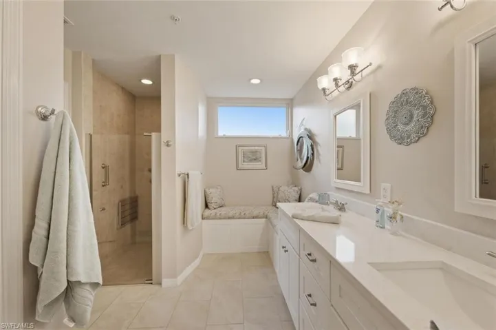 Full bath with double vanity, a shower stall, recessed lighting, and light tile patterned flooring