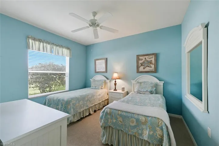 Carpeted bedroom featuring ceiling fan and baseboards
