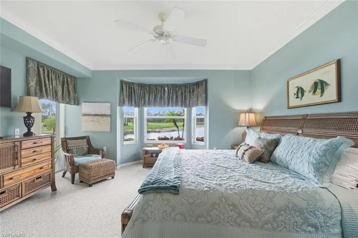 Carpeted bedroom with ceiling fan and ornamental molding