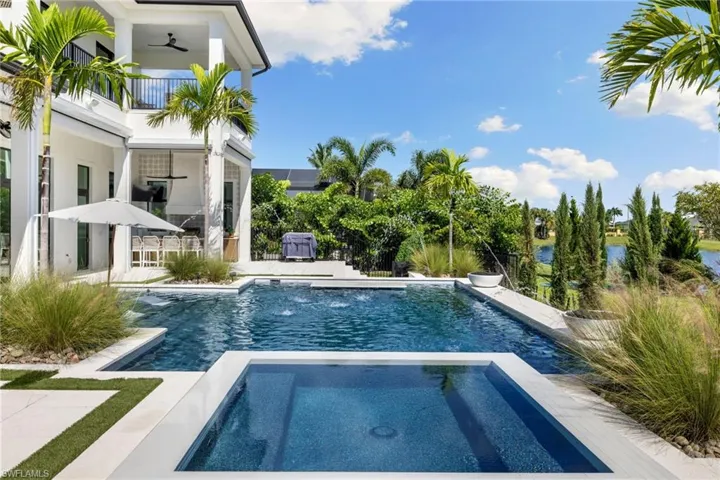 Integrated pool / spa with a patio area, a water view, and a balcony