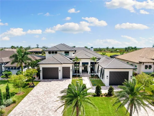View of front facade featuring an attached garage, decorative driveway, stucco siding, a tile roof, and a front yard
