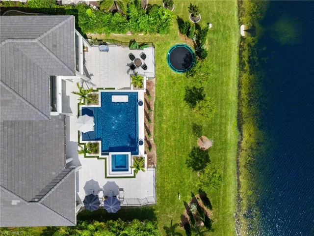 Aerial view of a pool area and a nearby body of water