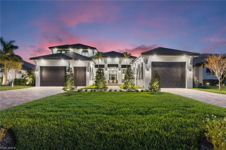View of front of home with a front lawn, decorative driveway, and an attached garage