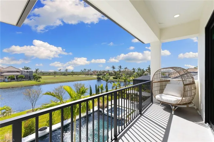 Balcony featuring a pool with connected hot tub and a water view