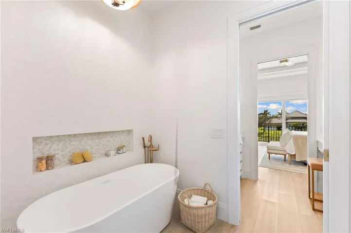 Ensuite bathroom with a freestanding bath and wood finished floors