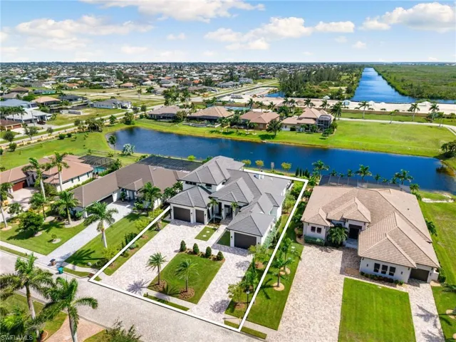 Aerial perspective of suburban area featuring a large body of water and property boundaries highlighted