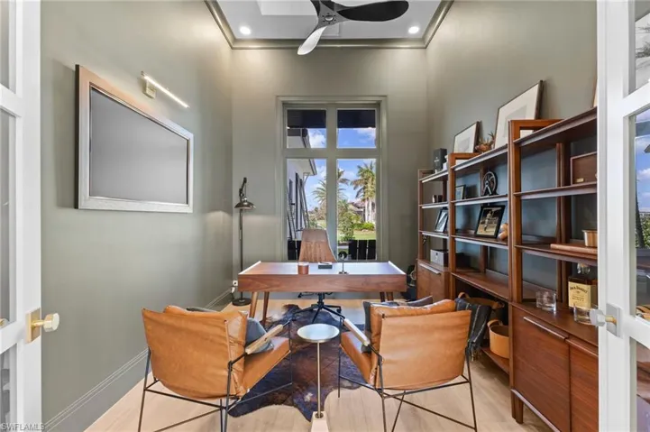 Office area featuring ceiling fan, a high ceiling, and light wood-style flooring