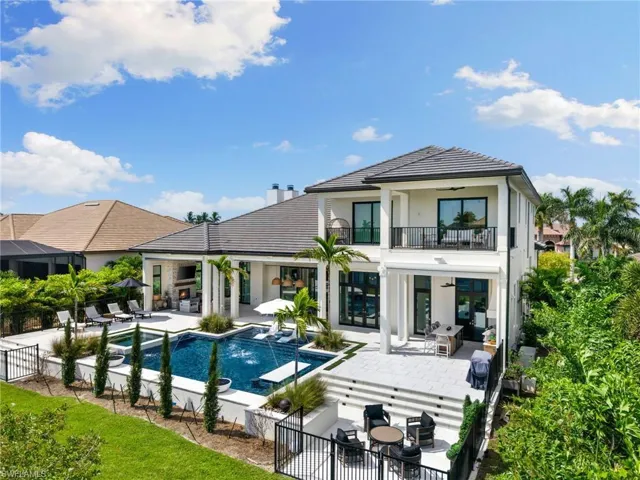 Back of house with a patio area, stucco siding, a fenced backyard, a pool with connected hot tub, and outdoor seating