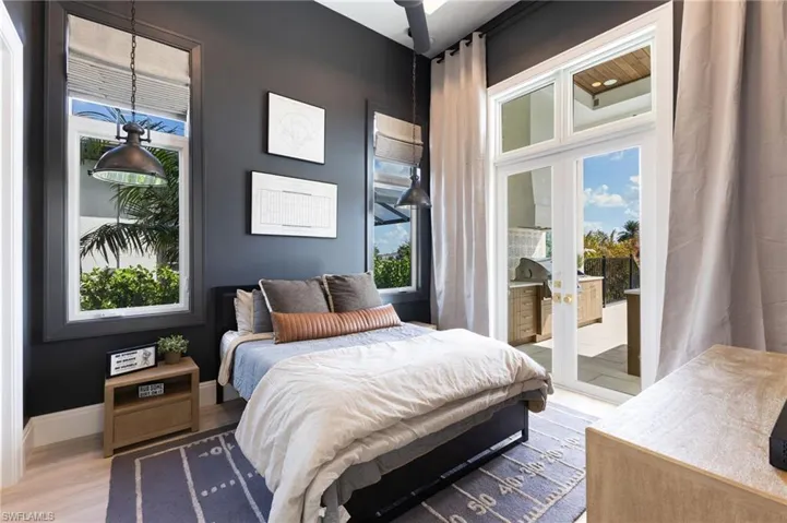 Bedroom featuring access to outside, wood finished floors, and french doors