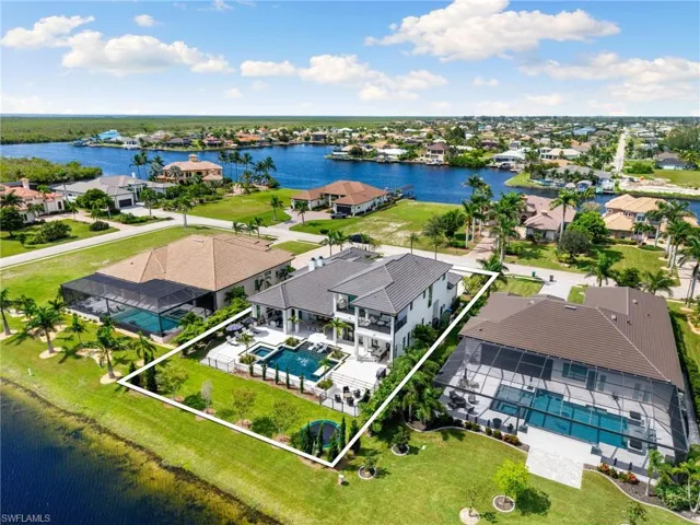 Aerial view of residential area featuring a nearby body of water and property parcel outlined