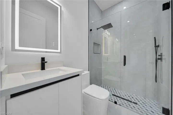Full bath with a shower stall and vanity