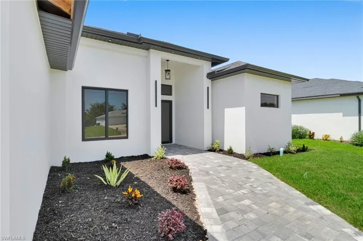 View of front of home featuring stucco siding and a front lawn