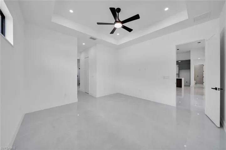 Spare room with a raised ceiling, a ceiling fan, and recessed lighting