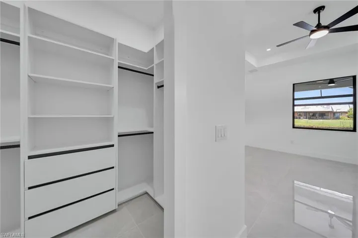 Spacious closet with ceiling fan and tile patterned flooring