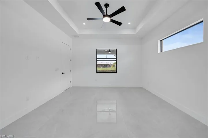 Unfurnished room with a tray ceiling, a ceiling fan, and recessed lighting
