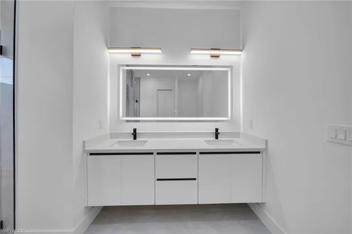 Full bath with double vanity and tile patterned flooring