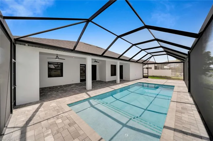 View of pool featuring a ceiling fan, a patio, and glass enclosure