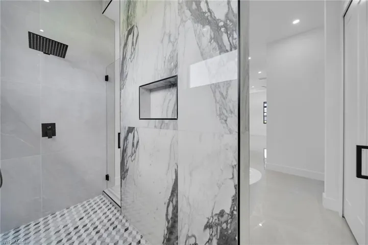 Full bath with a marble finish shower and recessed lighting