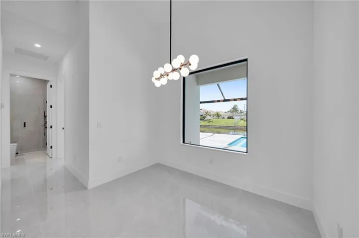 Spare room with a chandelier and light marble finish floors
