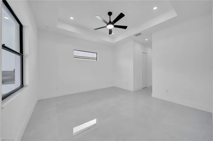 Unfurnished room featuring a raised ceiling, recessed lighting, and a ceiling fan