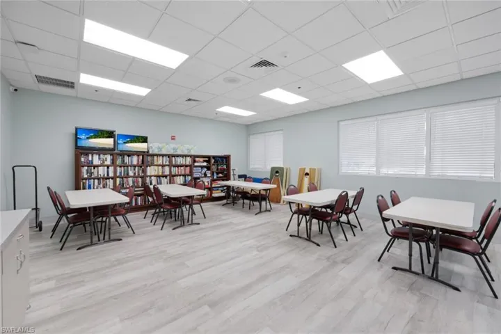 Dining space with a paneled ceiling and light hardwood / wood-style flooring