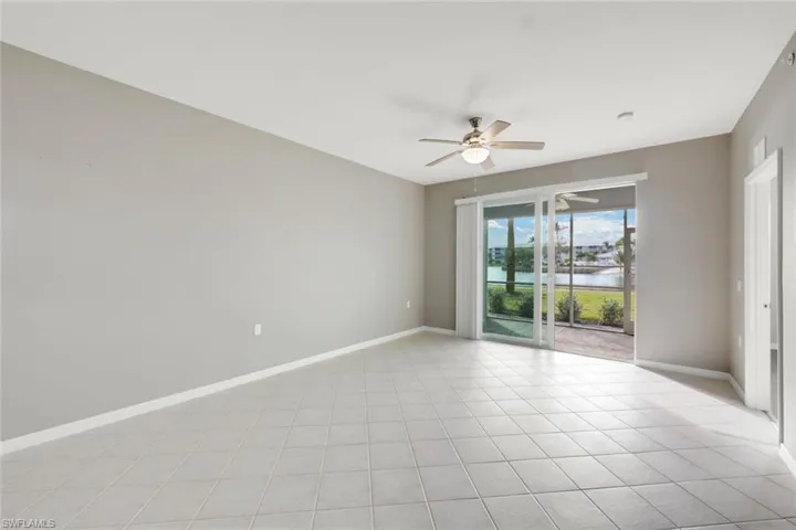 Tiled spare room featuring ceiling fan