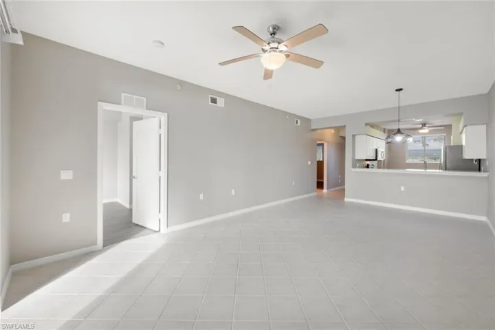 Unfurnished living room featuring ceiling fan and light tile patterned floors