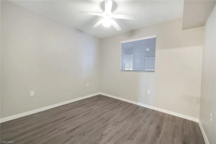 Unfurnished room featuring ceiling fan and dark hardwood / wood-style floors