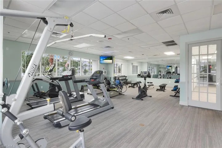 Gym featuring light colored carpet and a drop ceiling