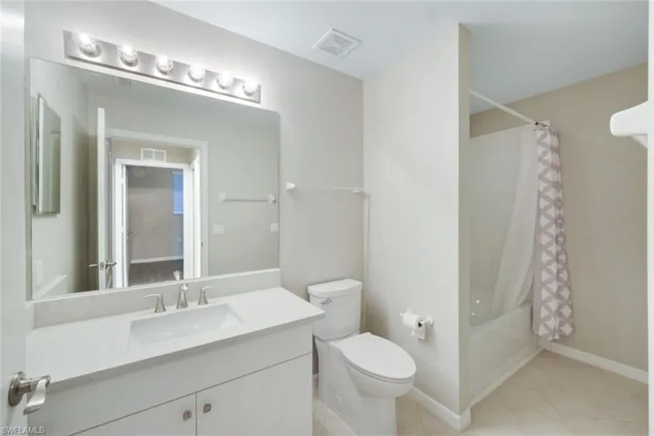Full bathroom with toilet, shower / tub combo, and vanity