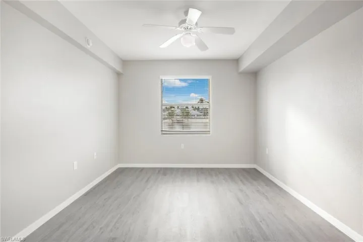 Empty room with ceiling fan and light hardwood / wood-style flooring