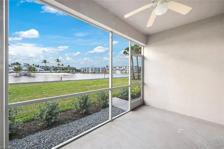 Unfurnished sunroom with ceiling fan and a water view
