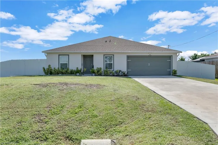 Ranch-style home with a garage and a front lawn