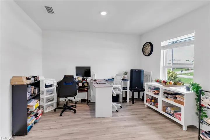 Office space with light hardwood / wood-style floors