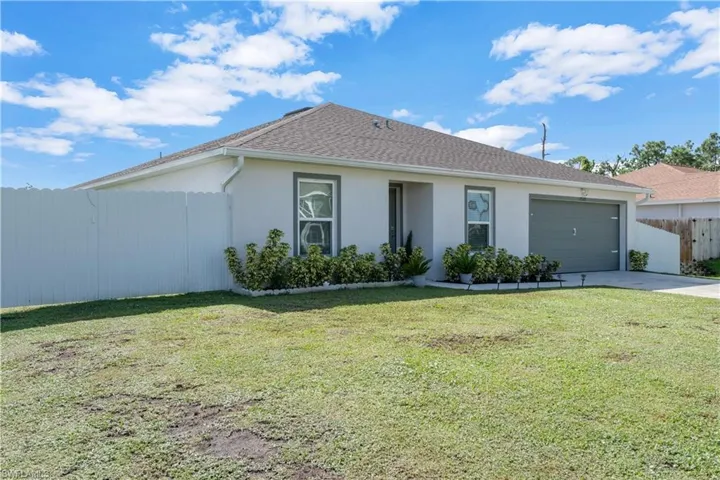 Single story home with a front yard and a garage