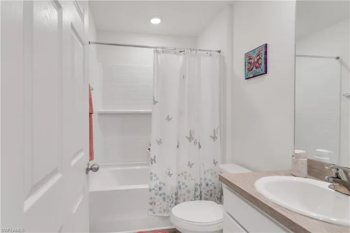 Full bathroom with toilet, vanity, and shower / tub combo